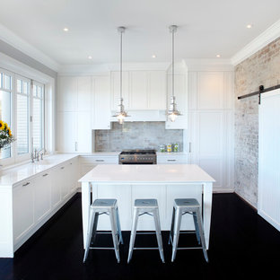 Modelo de cocina comedor en L, tradicional, de tamaño medio, con fregadero bajoencimera, armarios estilo shaker, puertas de armario blancas, encimera de cuarzo compacto, salpicadero de mármol, una isla, suelo negro y encimeras blancas