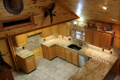 Example of a large mountain style u-shaped cement tile floor and gray floor eat-in kitchen design in Dallas with an undermount sink, raised-panel cabinets, light wood cabinets, granite countertops, multicolored backsplash, stone tile backsplash, stainless steel appliances, a peninsula and beige countertops