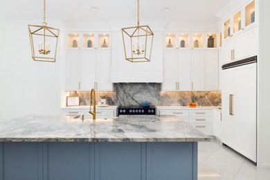 Inspiration for a large timeless l-shaped porcelain tile and white floor open concept kitchen remodel in Miami with a farmhouse sink, shaker cabinets, white cabinets, quartzite countertops, gray backsplash, stone slab backsplash, paneled appliances, an island and blue countertops