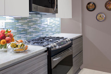 Example of a mid-sized minimalist single-wall porcelain tile eat-in kitchen design in New York with a single-bowl sink, flat-panel cabinets, gray cabinets, blue backsplash, stainless steel appliances, no island, granite countertops and mosaic tile backsplash