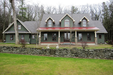 Large green two-story gable roof idea in Other