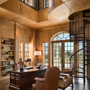 Bild på ett mycket stort vintage arbetsrum, med bruna väggar, mörkt trägolv och ett fristående skrivbord