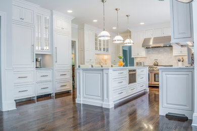 Large transitional u-shaped dark wood floor kitchen photo in New York with raised-panel cabinets, white cabinets, marble countertops and an island