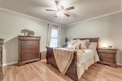 Example of a mid-sized classic master light wood floor and brown floor bedroom design in St Louis with green walls