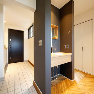 札幌の片開きドアトランジショナルスタイルのおしゃれな玄関ホール (白い壁、黒いドア、白い床) の写真