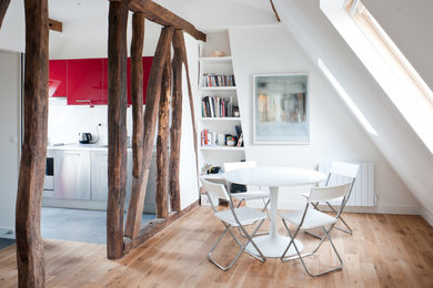 Contemporary separate dining room in Paris with white walls, light hardwood floors and no fireplace.