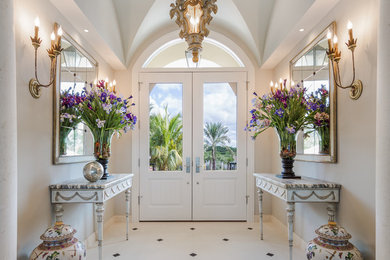 Entryway - traditional limestone floor entryway idea in Tampa with gray walls and a white front door