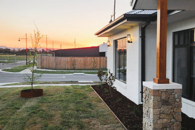 Design ideas for a country white house exterior in Melbourne with painted brick siding and board and batten siding.