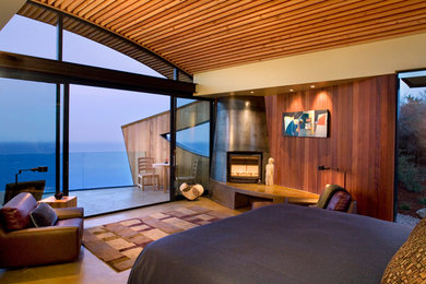 Photo of a mid-sized contemporary master bedroom in San Francisco with brown walls, a corner fireplace and brown floor.