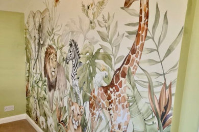 This is an example of a modern gender neutral kids' bedroom in Oxfordshire with green walls and wallpapered walls.