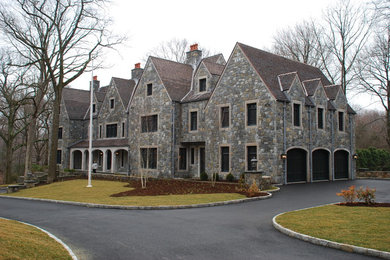 Example of a mid-sized classic two-story stone gable roof design in New York