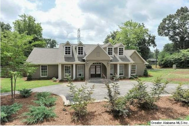 Large traditional brown two-story stucco exterior home idea in Birmingham with a hip roof