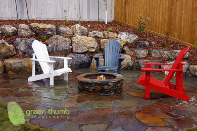Patio - large rustic backyard stone patio idea in Edmonton
