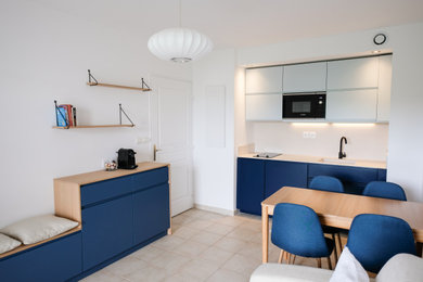 Exemple d'une petite cuisine ouverte linéaire, bicolore et encastrable moderne avec un évier encastré, un placard à porte plane, des portes de placard bleues, aucun îlot, une crédence blanche et un plan de travail blanc.