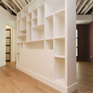 Idée de décoration pour un grand sous-sol design enterré avec salle de jeu, un mur blanc, un sol en vinyl, une cheminée standard, un manteau de cheminée en bois et un sol beige.