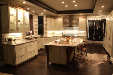 Enclosed kitchen - large contemporary u-shaped dark wood floor and brown floor enclosed kitchen idea in Atlanta with an undermount sink, shaker cabinets, white cabinets, quartz countertops, white backsplash, paneled appliances and an island