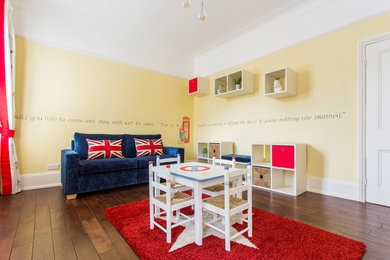 This is an example of a mid-sized traditional gender-neutral kids' room in London with yellow walls and dark hardwood floors.