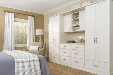 Mid-sized transitional gender-neutral dressing room in Chicago with shaker cabinets, white cabinets, medium hardwood floors and brown floor.