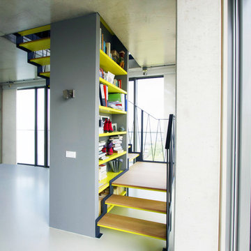 Moderne, halbgewendelte Podesttreppe mit Stahlwangen & integriertem Bücherregal