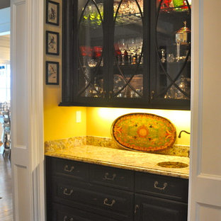 Mid-sized traditional kitchen pantry ideas - Kitchen pantry - mid-sized traditional single-wall medium tone wood floor kitchen pantry idea in Louisville with an undermount sink, raised-panel cabinets, dark wood cabinets, granite countertops, white backsplash, stone slab backsplash and black appliances
