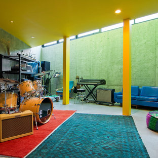 Diseño de sótano con ventanas contemporáneo, sin chimenea, con suelo de cemento y paredes grises