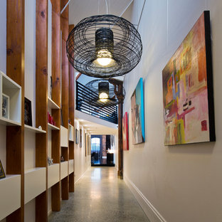 Inspiration för stora industriella hallar, med betonggolv, vita väggar och grått golv