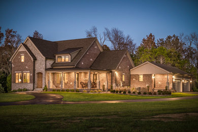 Inspiration for a large timeless brown two-story brick exterior home remodel in Other with a shingle roof and a gray roof