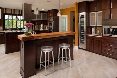 Eat-in kitchen - large contemporary u-shaped ceramic tile and beige floor eat-in kitchen idea in Columbus with an undermount sink, wood countertops, stainless steel appliances, flat-panel cabinets, dark wood cabinets and two islands