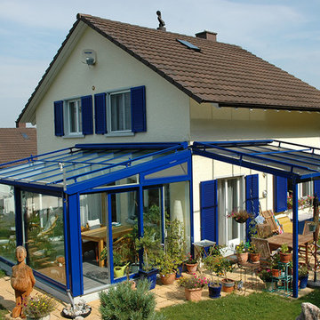 Blauer Holz-Alu Wintergarten mit passendem Terrassendach