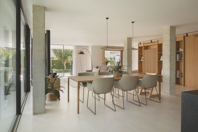 Foto di una grande sala da pranzo aperta verso il soggiorno minimalista con pavimento in pietra calcarea e camino lineare Ribbon