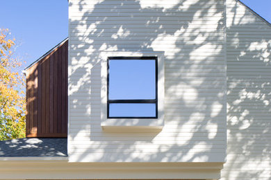 Large contemporary white two-story mixed siding house exterior idea in Detroit with a shingle roof and a shed roof
