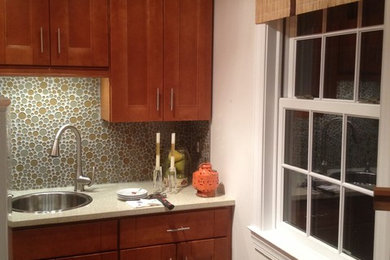 Example of a mid-sized trendy l-shaped medium tone wood floor enclosed kitchen design in DC Metro with a drop-in sink, recessed-panel cabinets, medium tone wood cabinets, multicolored backsplash, mosaic tile backsplash, white appliances and no island