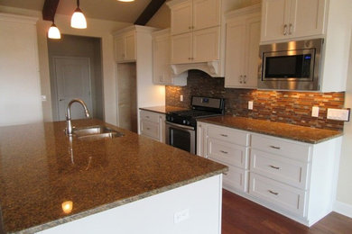 Inspiration for a large timeless galley medium tone wood floor and brown floor open concept kitchen remodel in Oklahoma City with a double-bowl sink, shaker cabinets, white cabinets, granite countertops, multicolored backsplash, matchstick tile backsplash, stainless steel appliances and an island