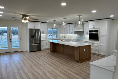 Large transitional u-shaped laminate floor and beige floor eat-in kitchen photo in Other with an undermount sink, shaker cabinets, white cabinets, quartz countertops, multicolored backsplash, marble backsplash, stainless steel appliances, an island and multicolored countertops