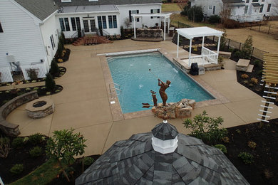 Pool - large traditional backyard rectangular pool idea in Other with decking