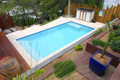Cette photo montre une piscine arrière chic de taille moyenne avec une terrasse en bois.