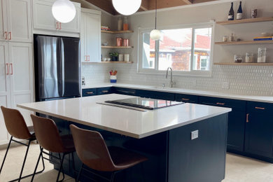 Eat-in kitchen - large mid-century modern l-shaped ceramic tile, beige floor and vaulted ceiling eat-in kitchen idea in San Francisco with an undermount sink, shaker cabinets, blue cabinets, quartz countertops, multicolored backsplash, ceramic backsplash, black appliances, an island and white countertops