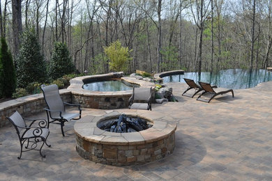 Photo of a mid-sized traditional sloped garden in Atlanta with a water feature and concrete pavers.