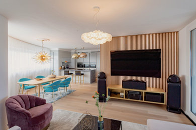 Diseño de salón abierto actual de tamaño medio con paredes marrones, suelo de madera clara, suelo marrón y televisor colgado en la pared
