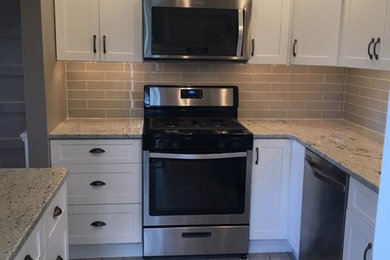 Inspiration for a small contemporary l-shaped ceramic tile eat-in kitchen remodel in Philadelphia with an undermount sink, shaker cabinets, white cabinets, granite countertops, gray backsplash, subway tile backsplash, stainless steel appliances and a peninsula