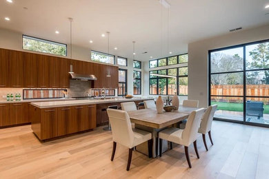 Photo of a large contemporary u-shaped eat-in kitchen in San Francisco with an undermount sink, flat-panel cabinets, brown cabinets, quartz benchtops, white splashback, marble splashback, stainless steel appliances, light hardwood floors, with island, beige floor and white benchtop.