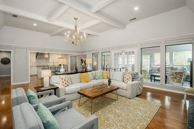 Inspiration for a mid-sized transitional open concept medium tone wood floor and brown floor living room remodel in Dallas with gray walls, a standard fireplace, a brick fireplace and a wall-mounted tv