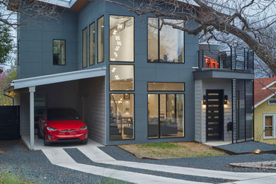 Photo of a contemporary two-storey grey house exterior in Austin with a metal roof.