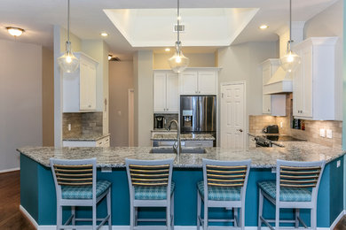 Inspiration for a large medium tone wood floor kitchen remodel in Houston with a double-bowl sink, shaker cabinets, white cabinets, granite countertops, gray backsplash, subway tile backsplash, stainless steel appliances and an island