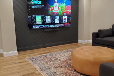 Inspiration for a large transitional walk-out laminate floor, brown floor and shiplap wall basement remodel in Cincinnati with a bar and beige walls