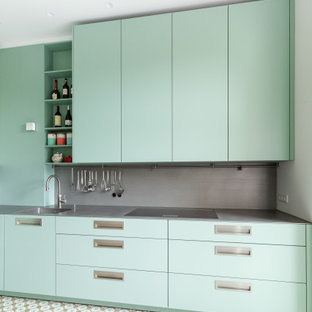 Удачное сочетание для дизайна помещения: маленькая отдельная, линейная кухня в современном стиле с монолитной раковиной, плоскими фасадами, искусственно-состаренными фасадами, столешницей из нержавеющей стали, серым фартуком, фартуком из металлической плитки, черной техникой, бирюзовым полом и серой столешницей - самое интересное для вас