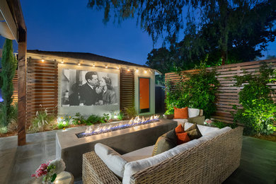 Example of a transitional patio design in Denver with a fire pit and no cover