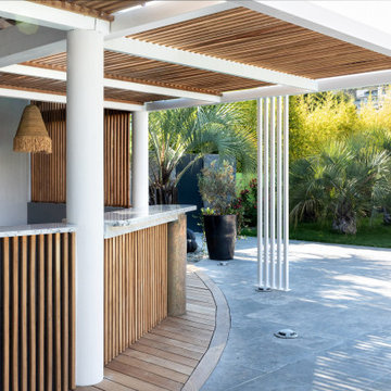Pergola bioclimatique, terrasse et plage piscine en bois exotique.