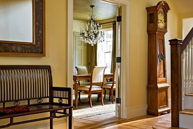 Huge elegant light wood floor and brown floor hallway photo in Other with yellow walls