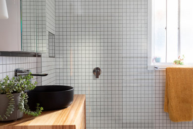 Design ideas for a small midcentury master wet room bathroom in Hobart with recessed-panel cabinets, medium wood cabinets, a corner tub, black and white tile, ceramic tile, white walls, ceramic floors, wood benchtops, white floor, an open shower, a niche, a single vanity and a floating vanity.